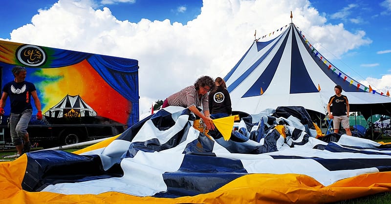 Let's Circus team members build their colourful circus tents for a festival zone.